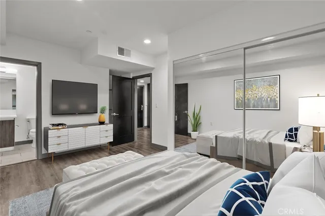 a kitchen with stainless steel appliances granite countertop a refrigerator a sink dishwasher and a oven with wooden floor