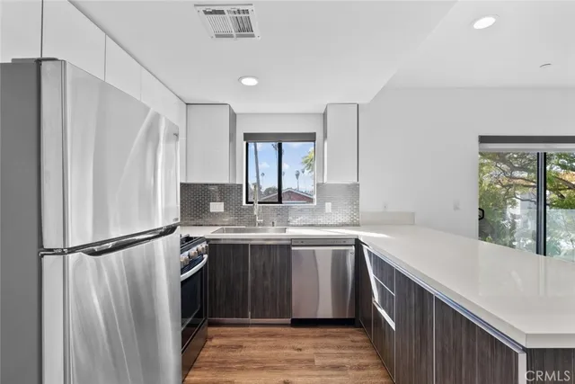 a kitchen with stainless steel appliances granite countertop a refrigerator sink and stove