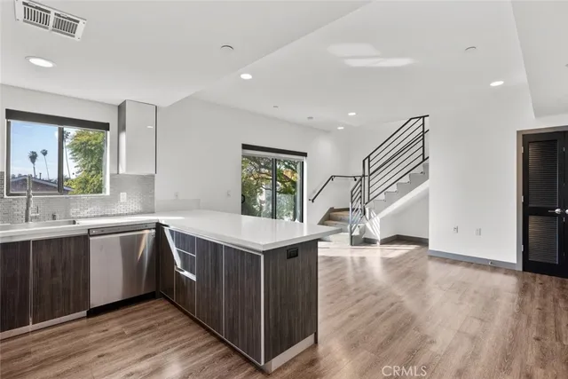 a view of a kitchen with wooden floor and stairs