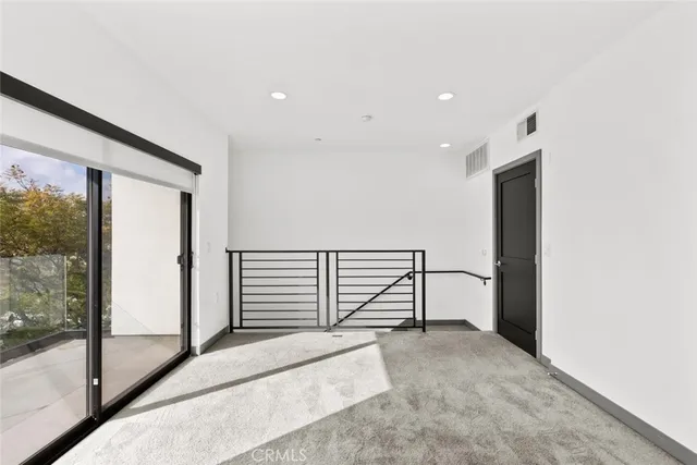a view of entryway and kitchen with wooden floor