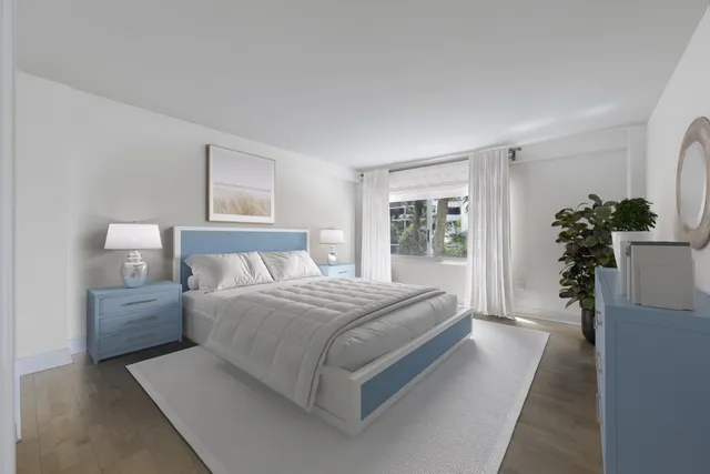 a bedroom with a large bed and a potted plant