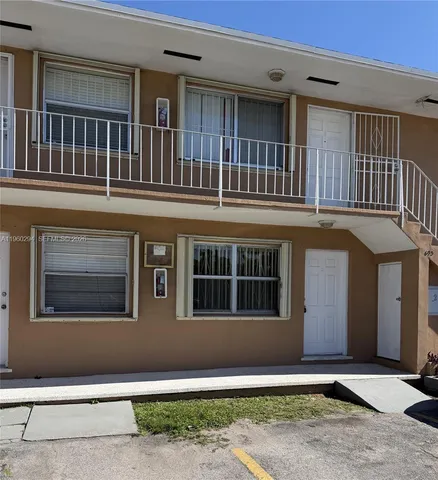 a front view of a house with large windows and fence