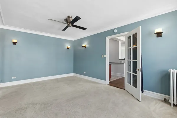 a view of empty room with wooden floor and ceiling fan