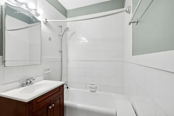 a bathroom with a sink vanity granite tub shower and a mirror