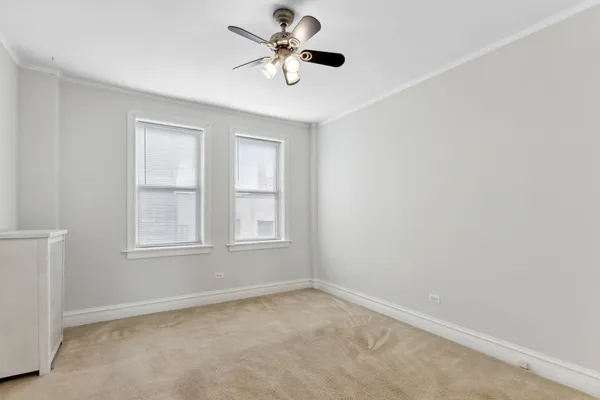 an empty room with a window and a fan