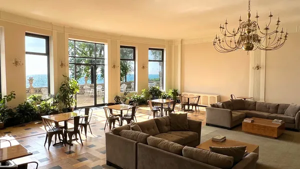 a living room with furniture and floor to ceiling windows