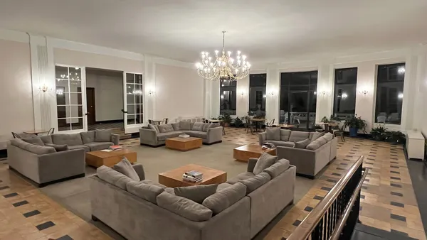 a living room with furniture chandelier and kitchen view
