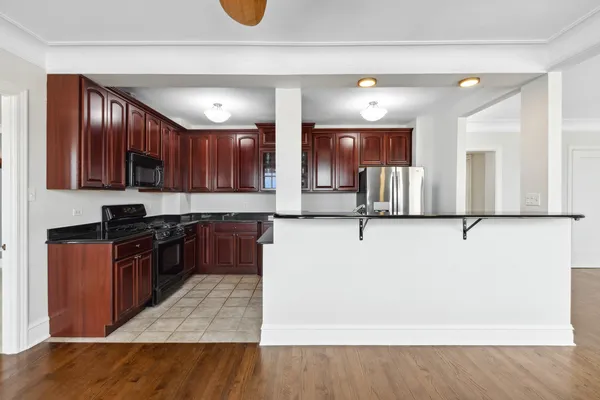 a kitchen with stainless steel appliances granite countertop wooden cabinets a refrigerator and a sink