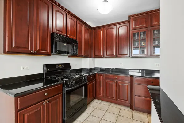 a kitchen with granite countertop wooden cabinets and stainless steel appliances