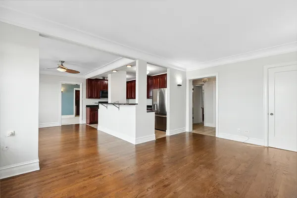 a view of a kitchen with wooden floor and a refrigerator