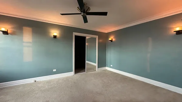 an empty room with closet and fan