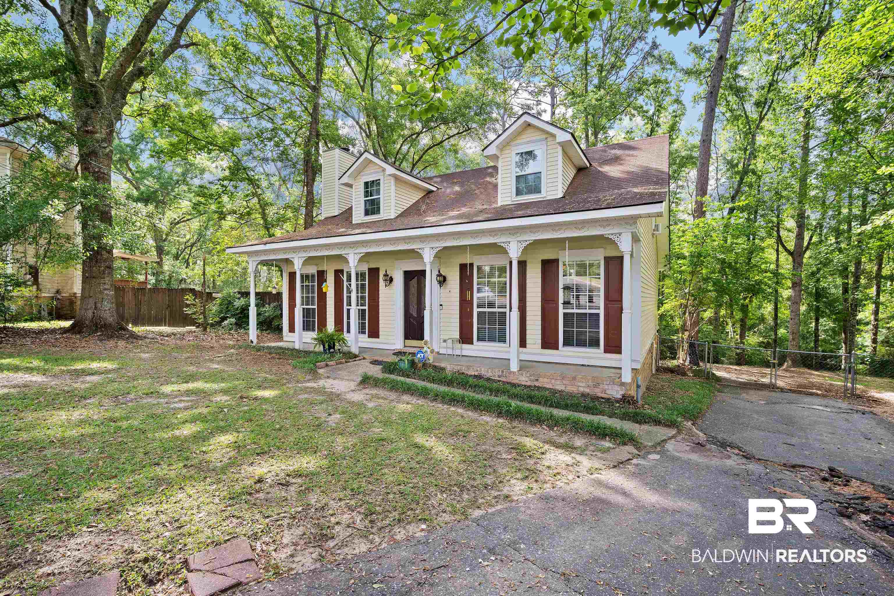 2823 Woodland Road Mobile, AL 36693 - Photo 28 of 29 View of front facade featuring fence, driveway, a chimney, and covered porch