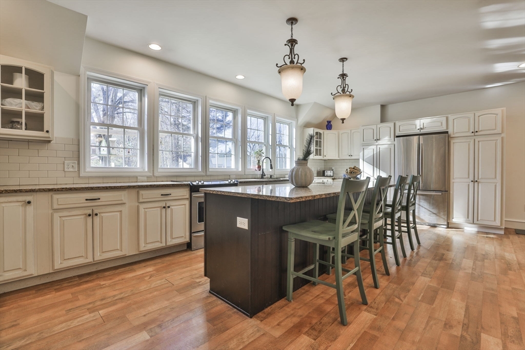 207 Oakridge Road Plaistow, NH 03865 - Photo 13 of 42 a kitchen with a table chairs and wooden floor