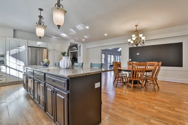 a kitchen with granite countertop a table chairs stove and cabinets