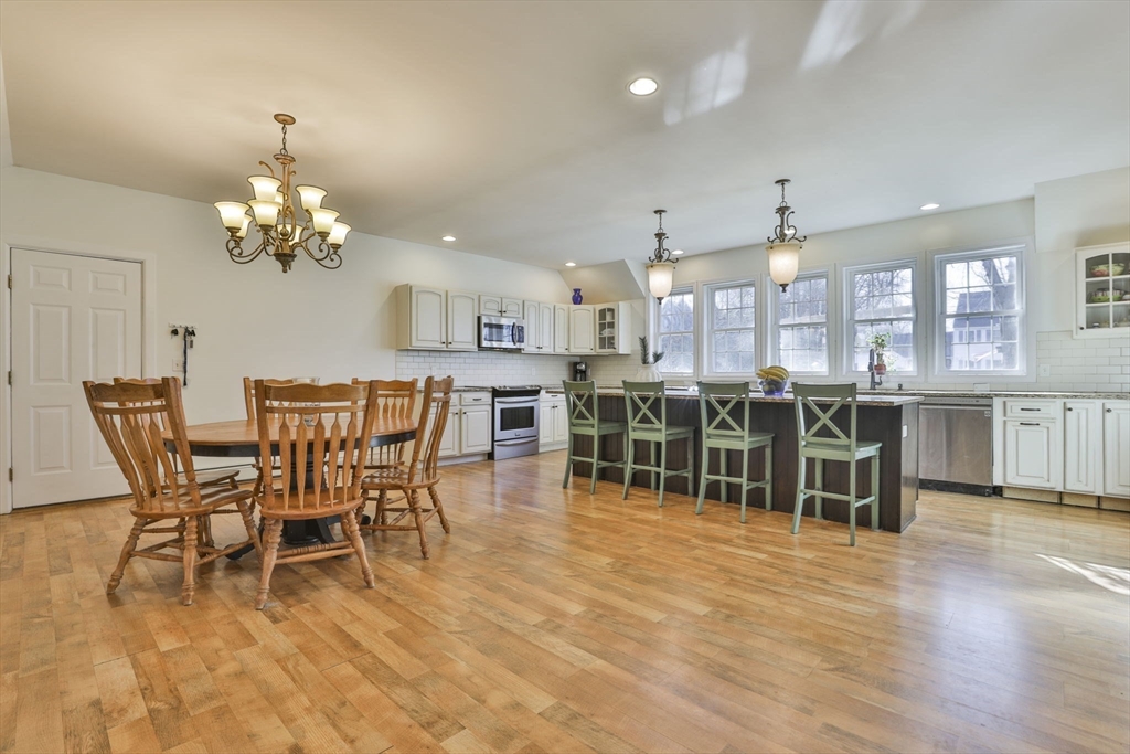 207 Oakridge Road Plaistow, NH 03865 - Photo 16 of 42 a dining room with furniture a chandelier a kitchen view and a large window