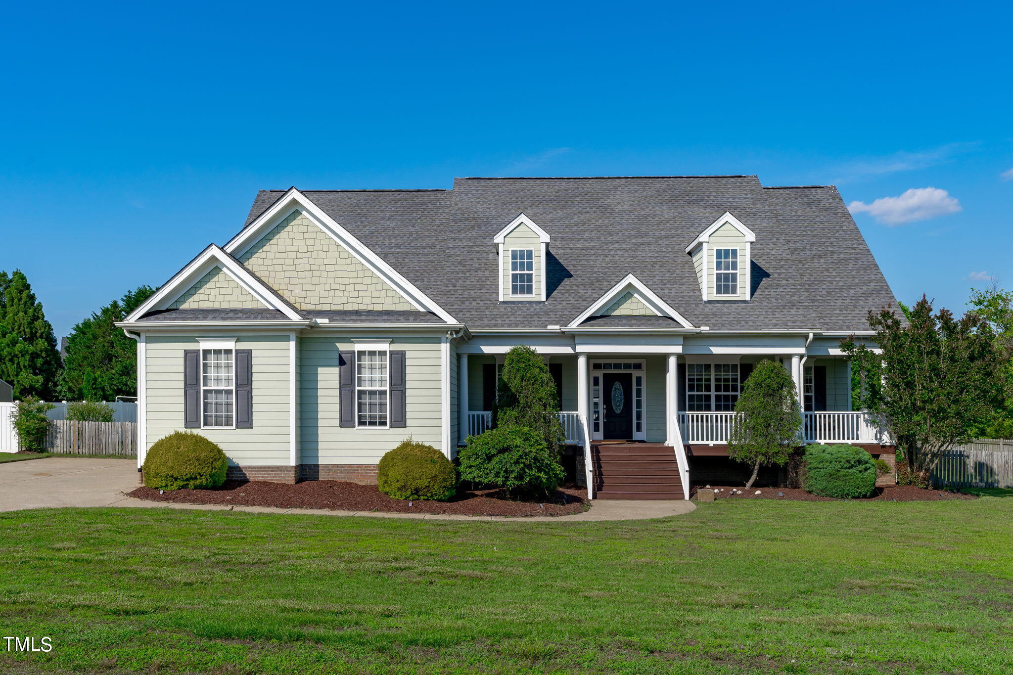 a view of a house with a yard and potted plants