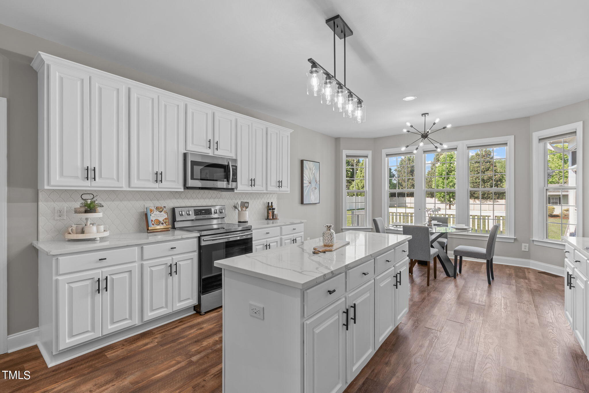 7409 Ladora Drive Willow Spring, NC 27592 - Photo 11 of 33 a open kitchen with white cabinets and wooden floor