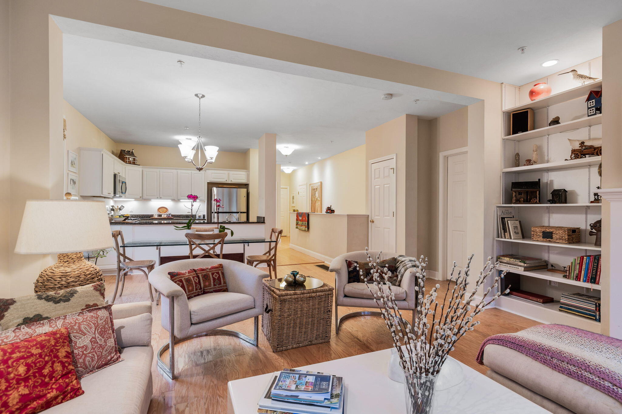 16 Grey Hawk Drive, Unit 16 Mashpee, MA 02649 - Photo 8 of 29 a living room with furniture a chandelier and kitchen view