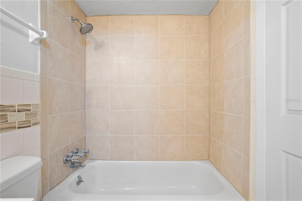 303 Ridge Boulevard, Unit 110 South Daytona, FL 32119 - Photo 14 of 33 a bathroom with a shower and a toilet
