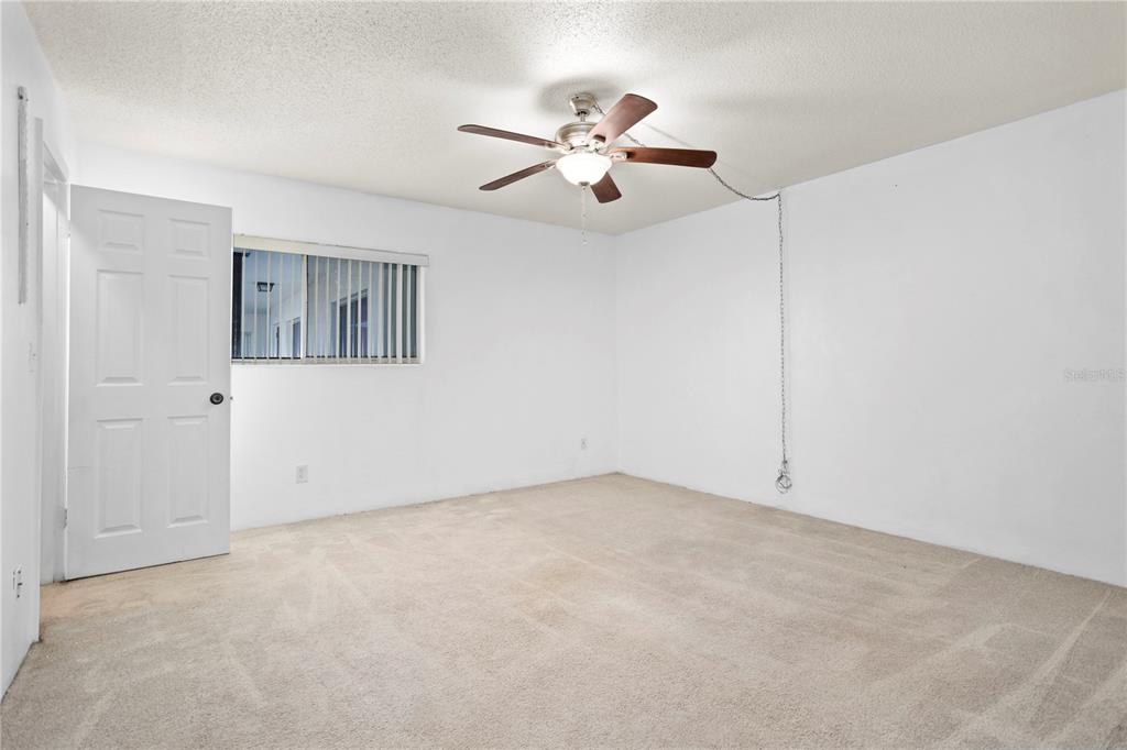 303 Ridge Boulevard, Unit 110 South Daytona, FL 32119 - Photo 10 of 33 an empty room with fan and windows