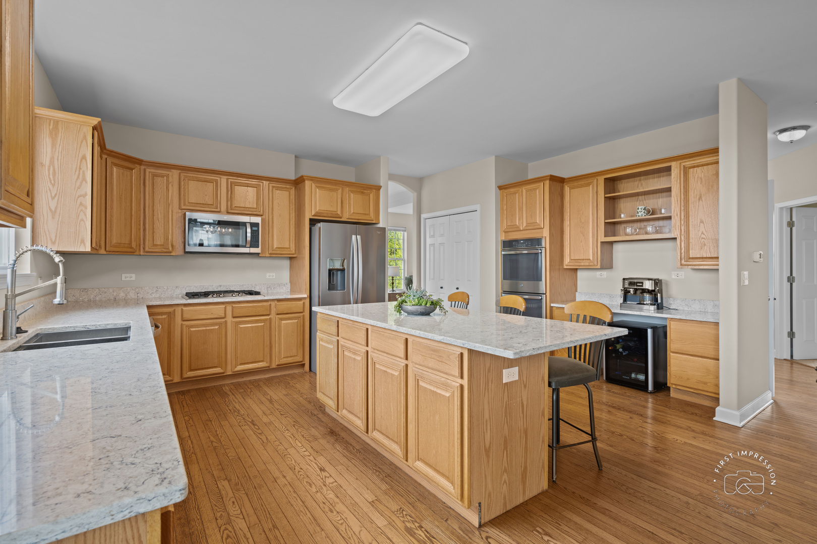 334 Willowbrook Way Geneva, IL 60134 - Photo 7 of 34 a kitchen with stainless steel appliances granite countertop sink stove top oven and wooden floor