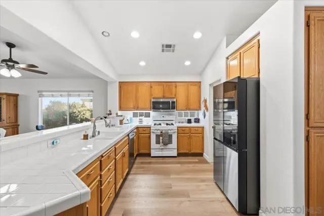 a large kitchen with stainless steel appliances a sink and large window