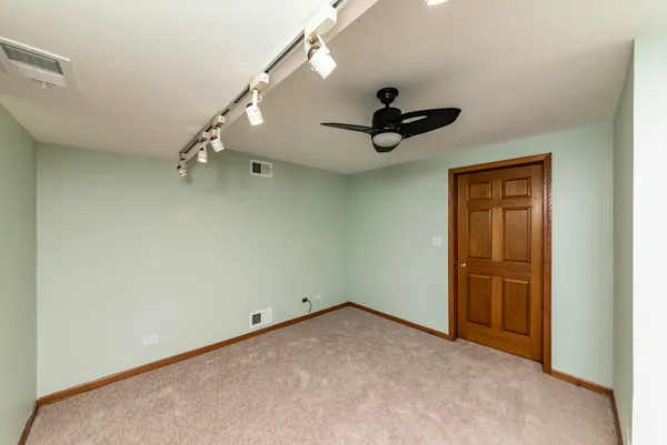 an empty room with a ceiling fan and window