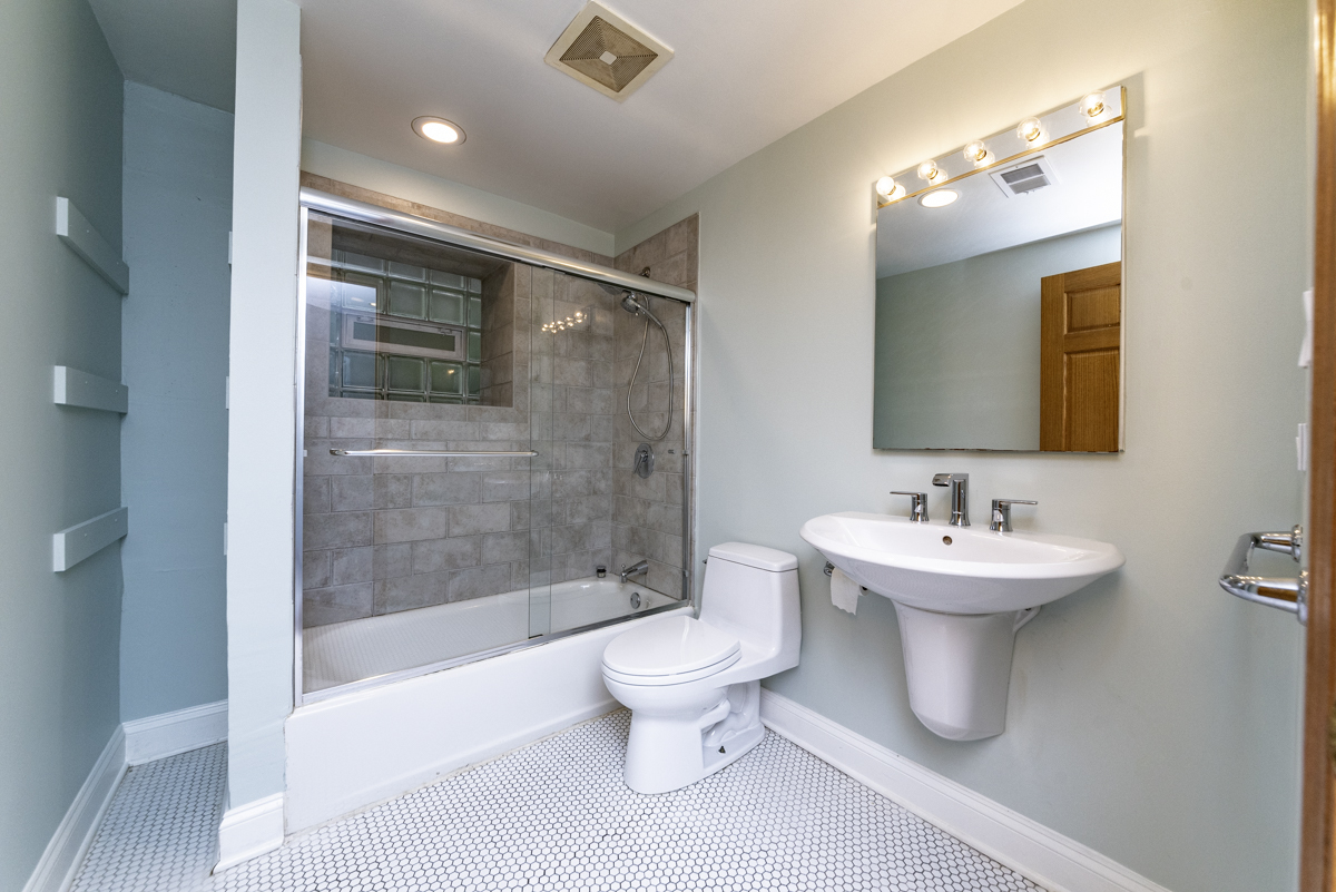 4625 North Dover Street, Unit G Chicago, IL 60640 - Photo 16 of 26 a bathroom with a sink a toilet and shower