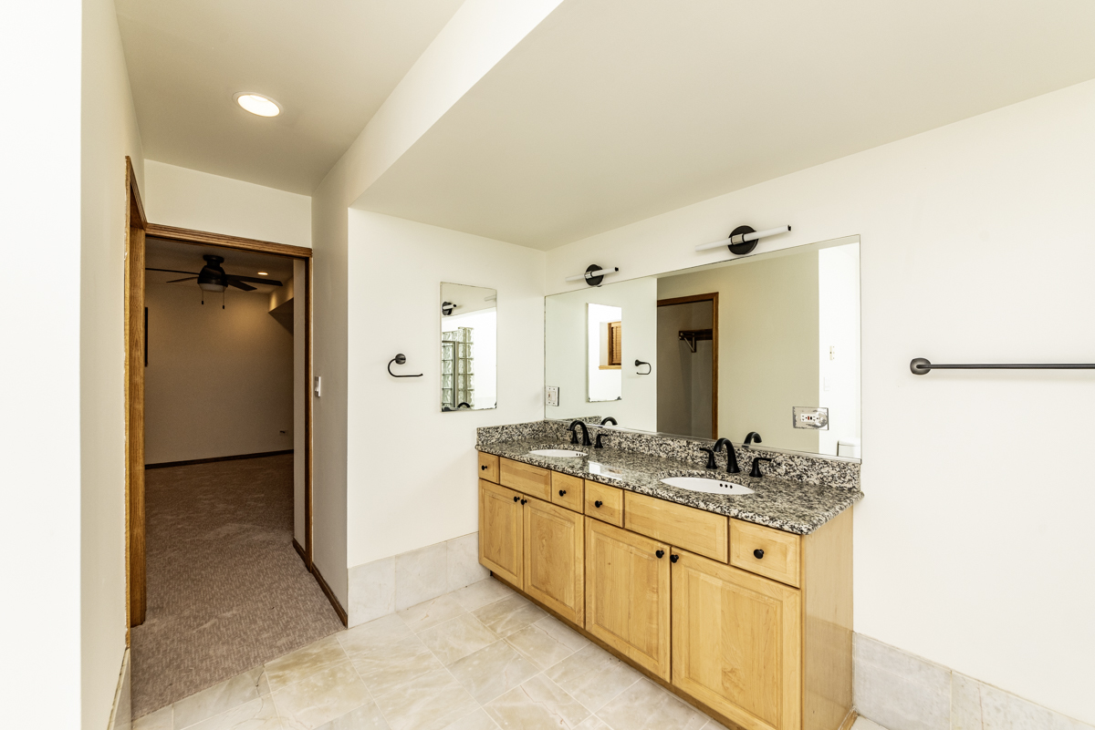 4625 North Dover Street, Unit G Chicago, IL 60640 - Photo 23 of 26 a spacious bathroom with a granite countertop sink and a mirror