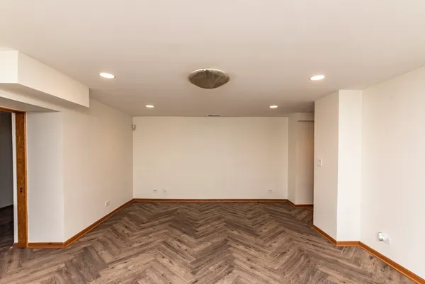 a view of a room has wooden floor and fan