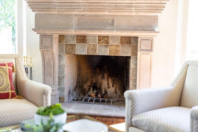 a living room with furniture fireplace and a large window