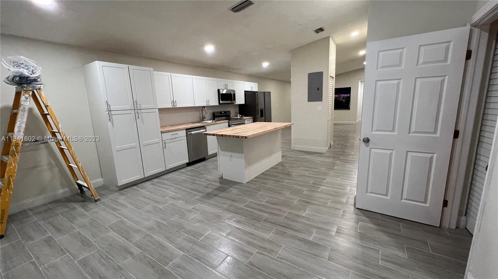 Sunset Miami, FL 33173 - Photo 12 of 41 a kitchen with white cabinets and stainless steel appliances