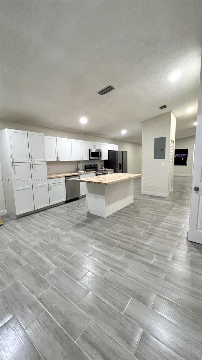 Sunset Miami, FL 33173 - Photo 13 of 41 a large white kitchen with kitchen island a sink a stove and a refrigerator