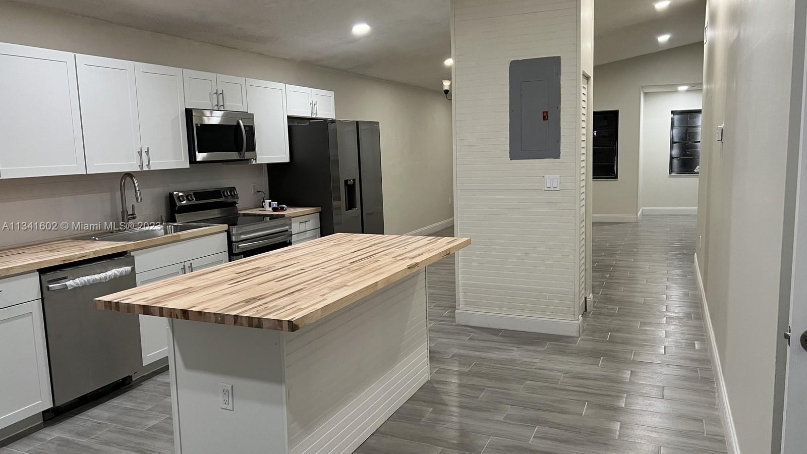 Sunset Miami, FL 33173 - Photo 15 of 41 a kitchen with stainless steel appliances kitchen island sink refrigerator and microwave