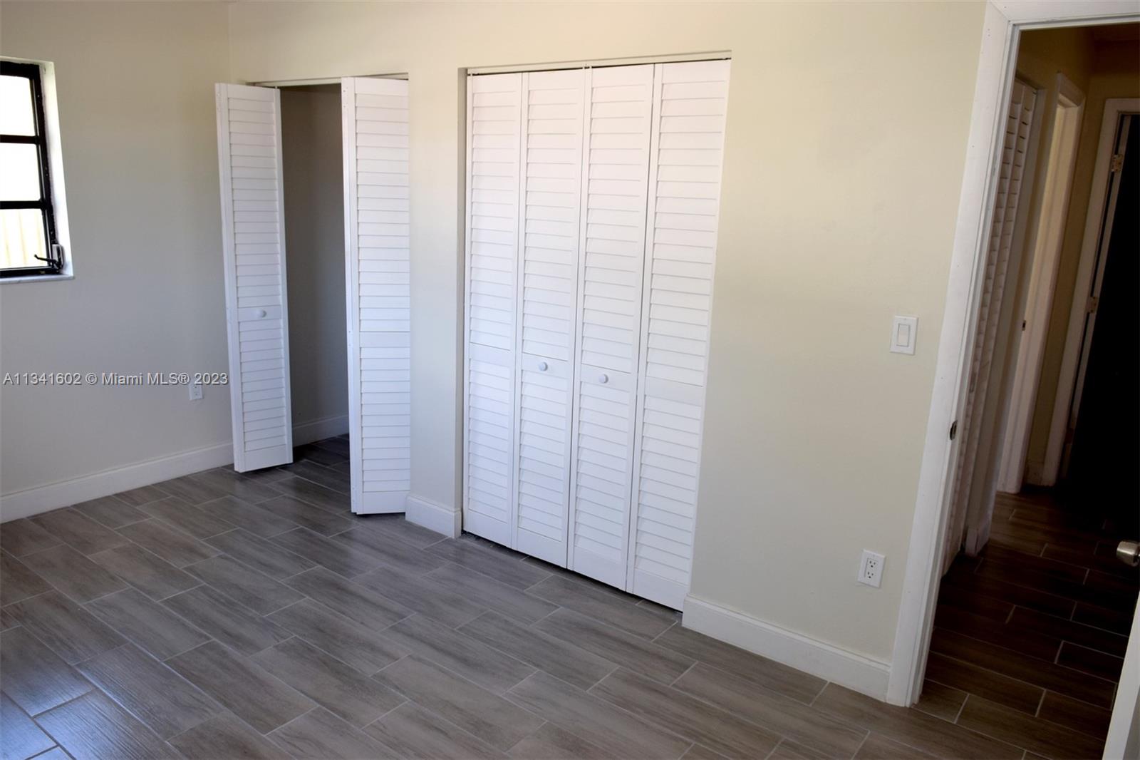 Sunset Miami, FL 33173 - Photo 33 of 41 an empty room with wooden floor and a window