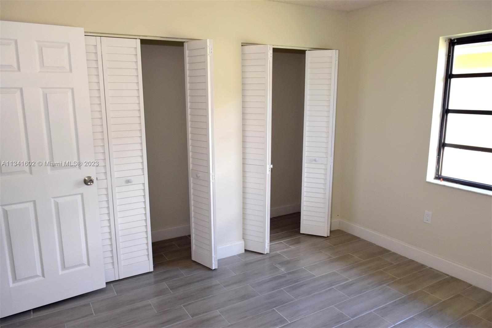 Sunset Miami, FL 33173 - Photo 37 of 41 an empty room with wooden floor and windows