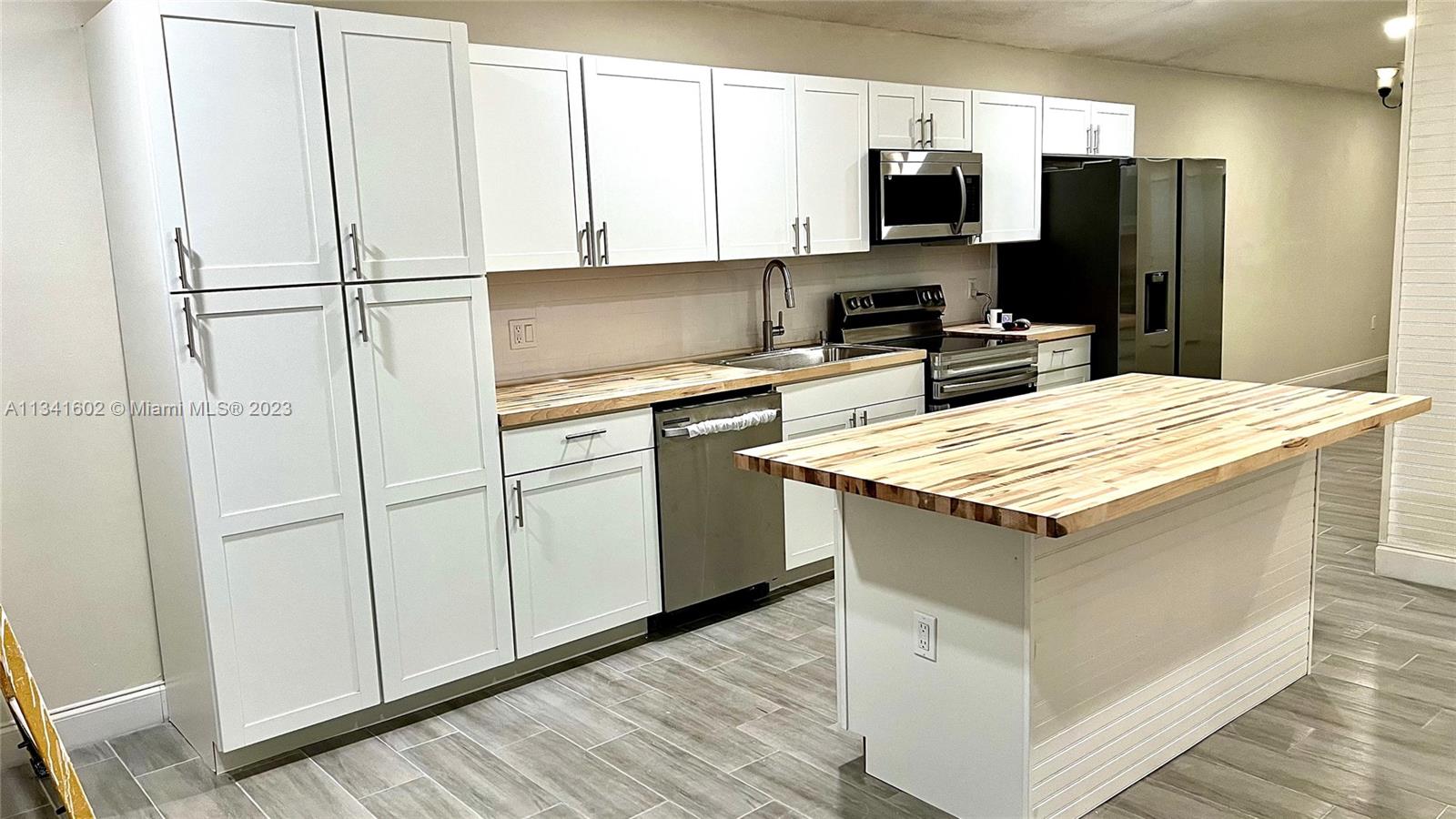 Sunset Miami, FL 33173 - Photo 10 of 41 a kitchen with a refrigerator a stove top oven a sink and dishwasher with wooden floor