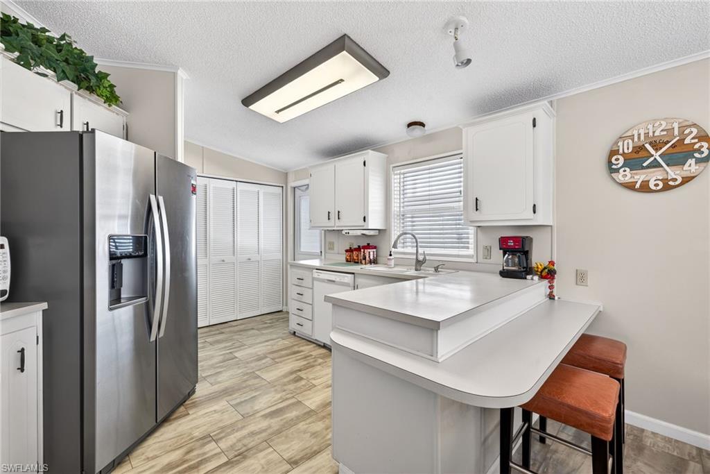 212 Oceans Boulevard, Unit 212 Naples, FL 34104 - Photo 11 of 30 a white kitchen with a refrigerator a stove a sink and a refrigerator