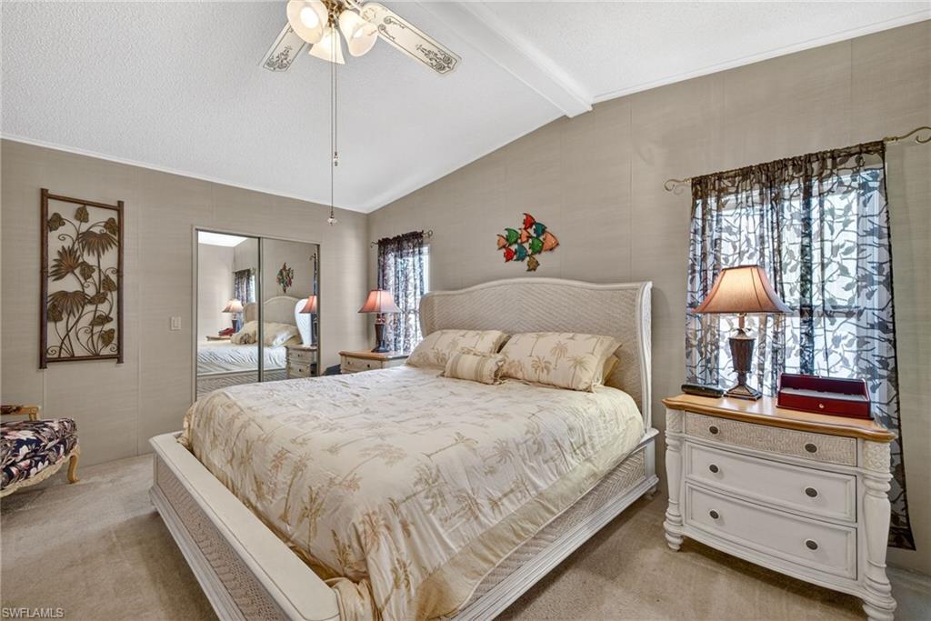 212 Oceans Boulevard, Unit 212 Naples, FL 34104 - Photo 14 of 30 a bedroom with a large bed and a chandelier