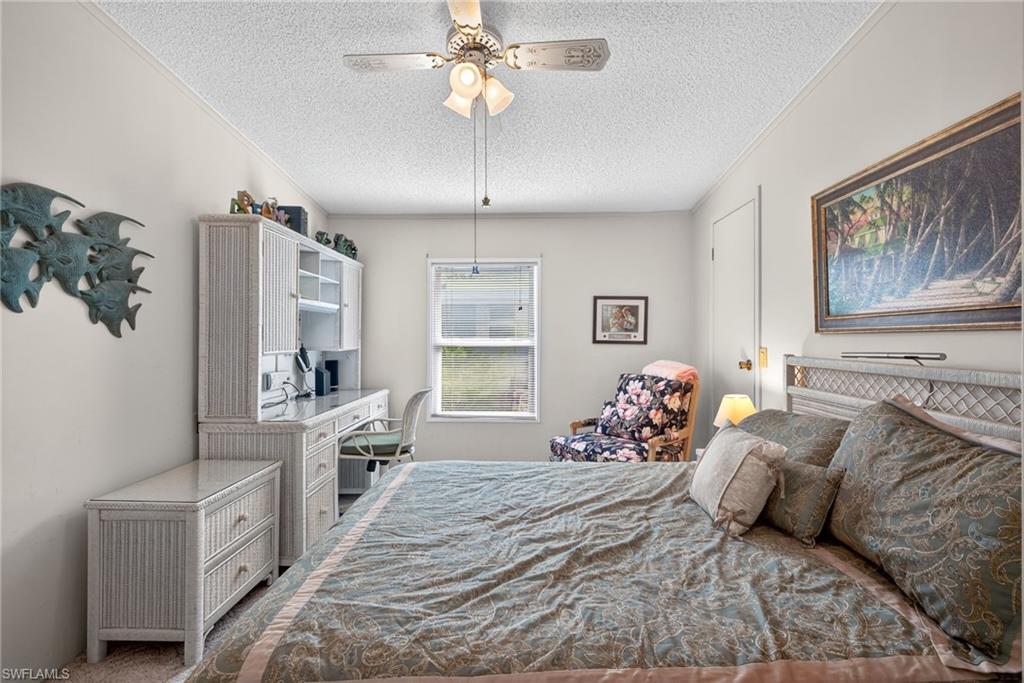 212 Oceans Boulevard, Unit 212 Naples, FL 34104 - Photo 18 of 30 a bedroom with a large bed and a chandelier