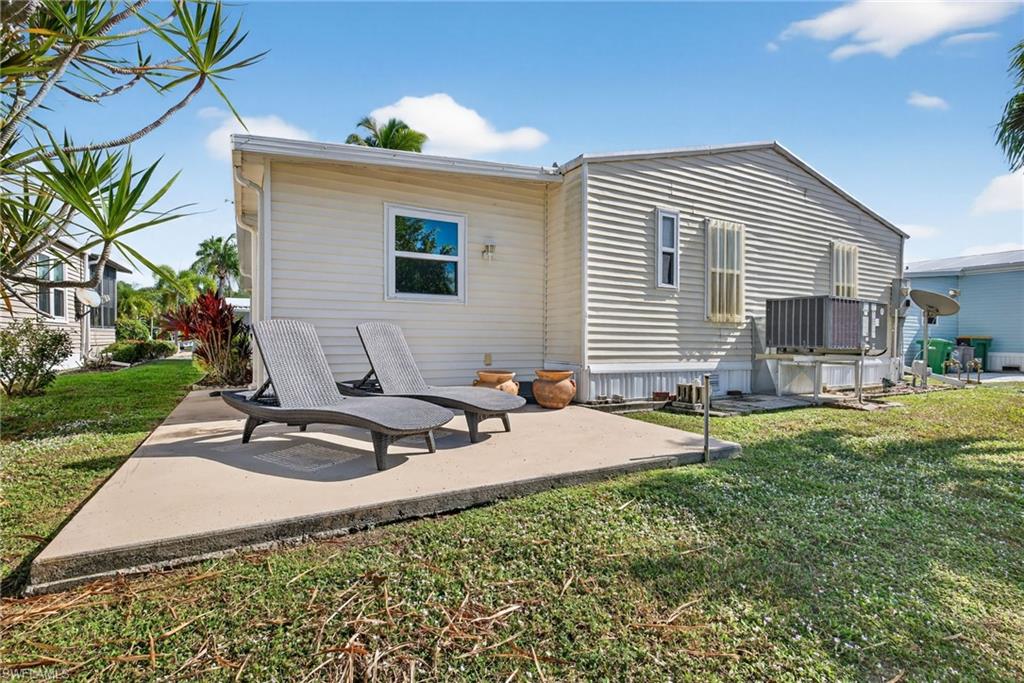 212 Oceans Boulevard, Unit 212 Naples, FL 34104 - Photo 23 of 30 a backyard of a house with table and chairs