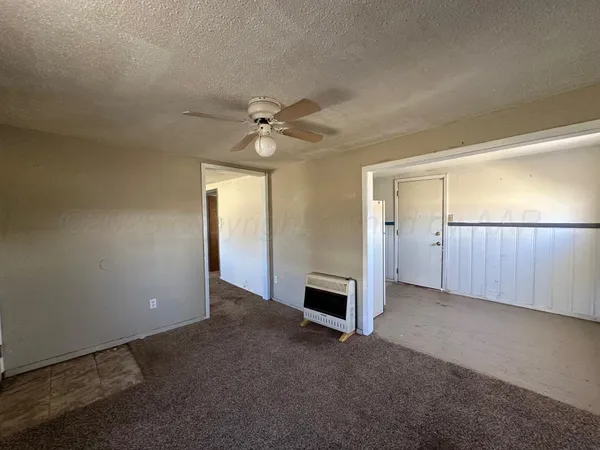 an empty room with fan and windows