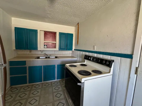 a kitchen that has a sink and a stove in it