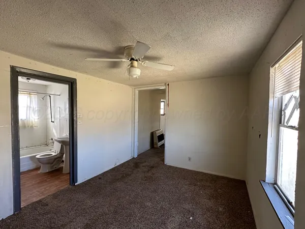 wooden floor in an empty room with a bathroom