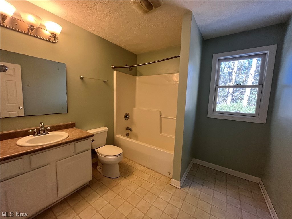 2819 Best Road Cambridge, OH 43725 - Photo 24 of 33 Full bathroom featuring vanity, shower / tub combination, a textured ceiling, toilet, and tile floors