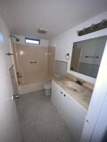 a bathroom with a double vanity sink toilet mirror and bathtub
