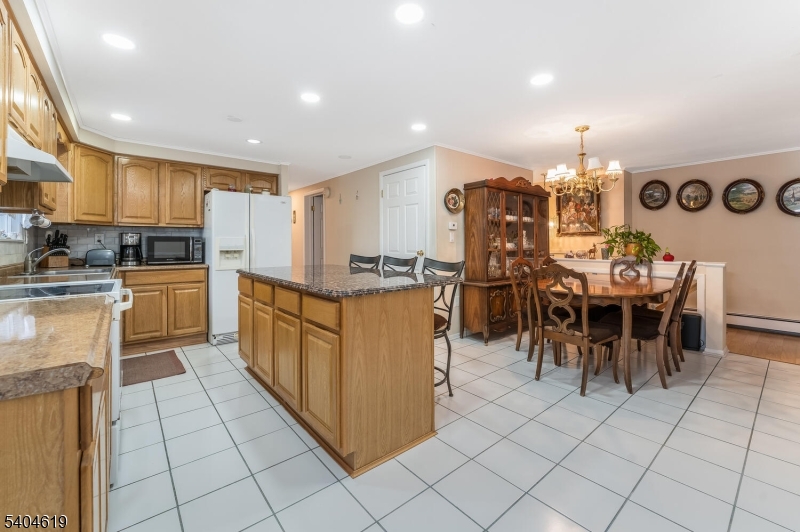 11 Cemetery Road Blairstown, NJ 07825 - Photo 22 of 34 a kitchen with stainless steel appliances granite countertop a stove top oven a sink a dining table and chairs