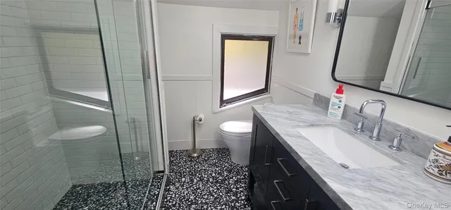 a bathroom with a granite countertop sink toilet and shower