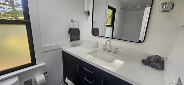 a bathroom with a sink vanity and a mirror