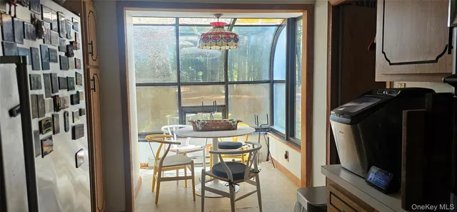 a dining room with furniture and a floor to ceiling window